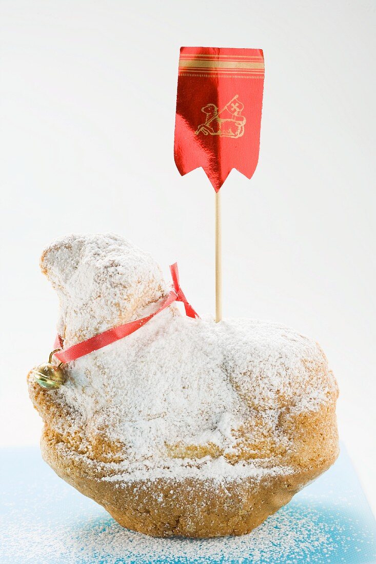 A sweet Easter lamb dusted with icing sugar and decorated with a red flag
