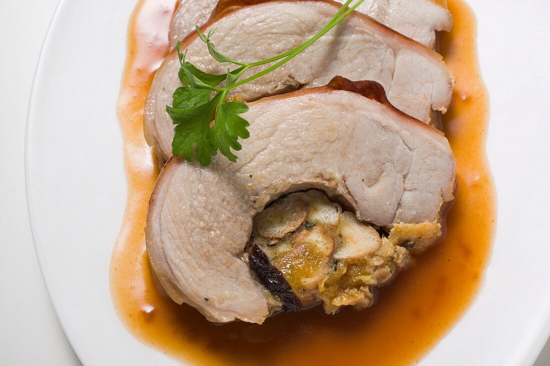 Three slices of stuffed roast pork with gravy (close-up)