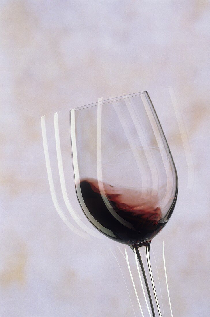 Ein Glas Rotwein (Rotwein kreist im Glas)