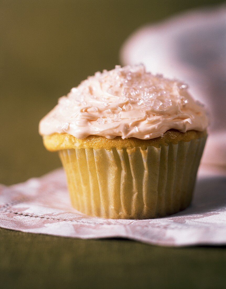 Muffin (bzw.Cupcake) mit rosa Cremeglasur in Papiermanschette