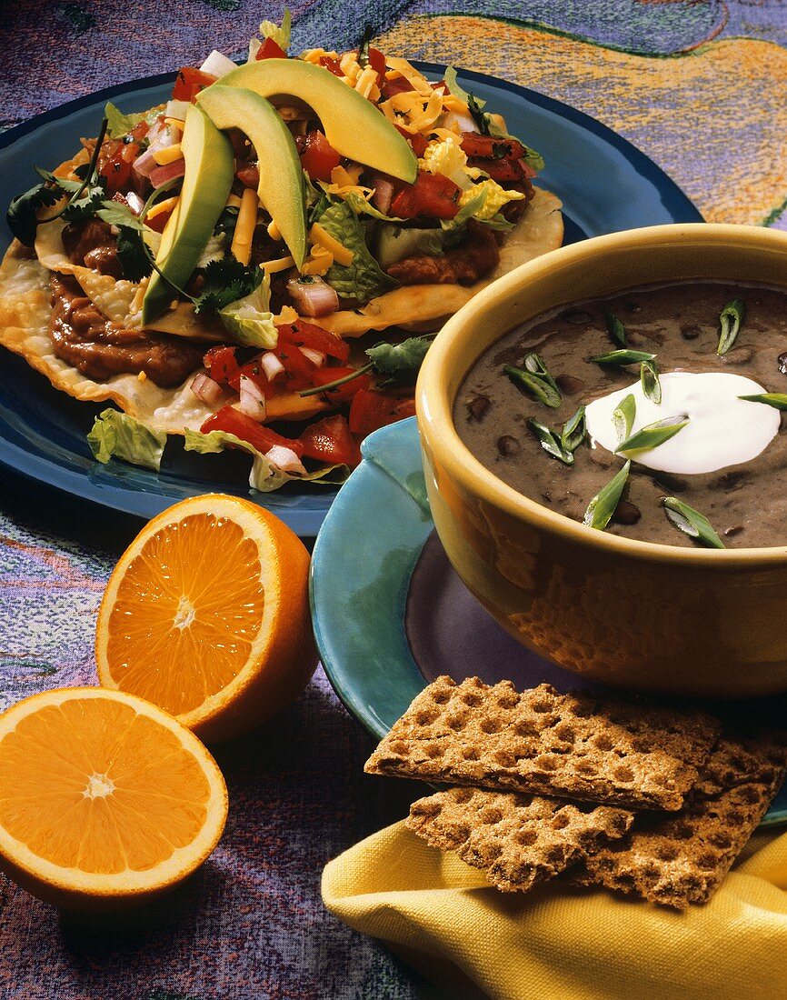 Zwei mexikanische Gerichte: schwarze Bohnensuppe und Tostada