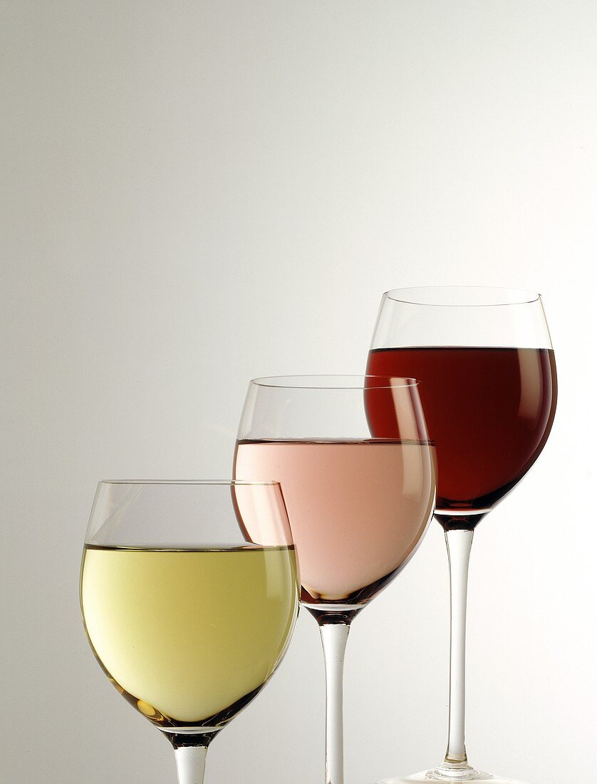 Drei Weingläser hintereinander: Weißwein, Rotwein, Rose
