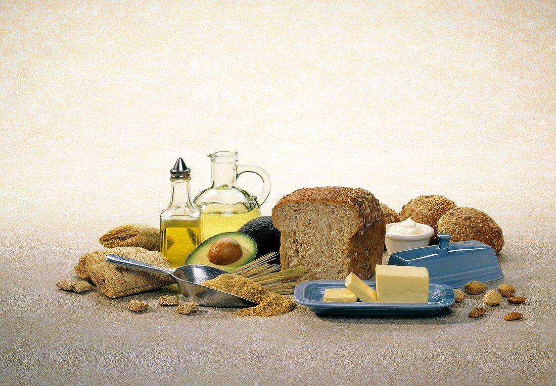 Stillleben mit Brot, Getreide, Butter, Öl, Avocado und Nüssen