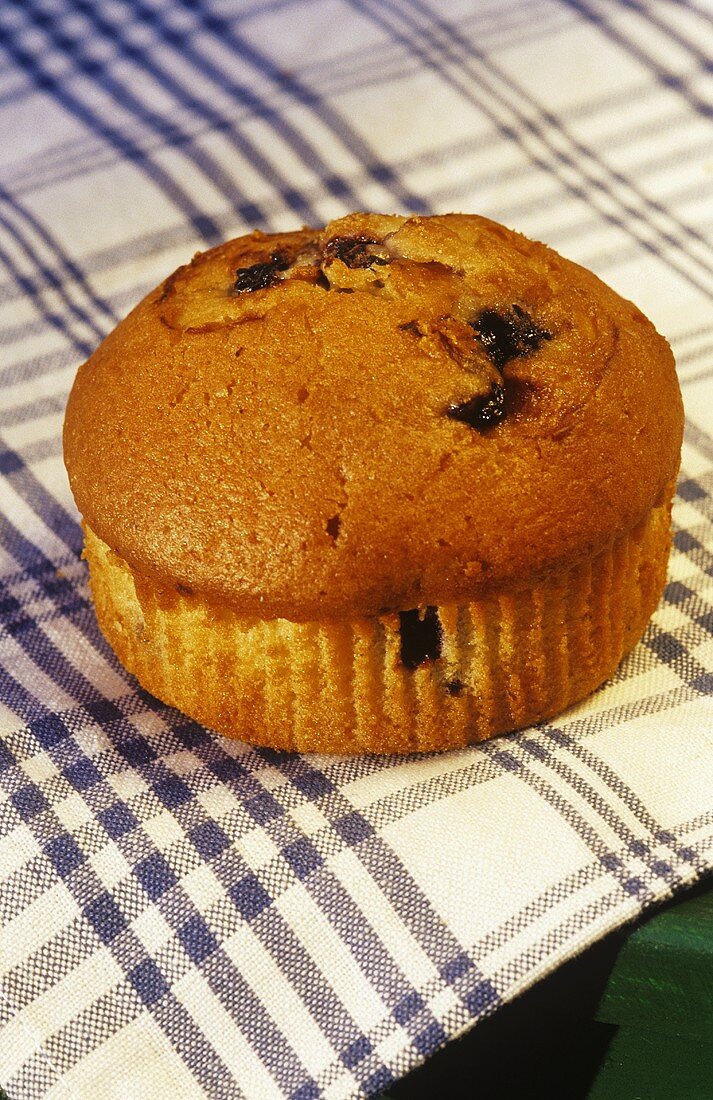 Single Blueberry Muffin on Blue and White Dish Cloth