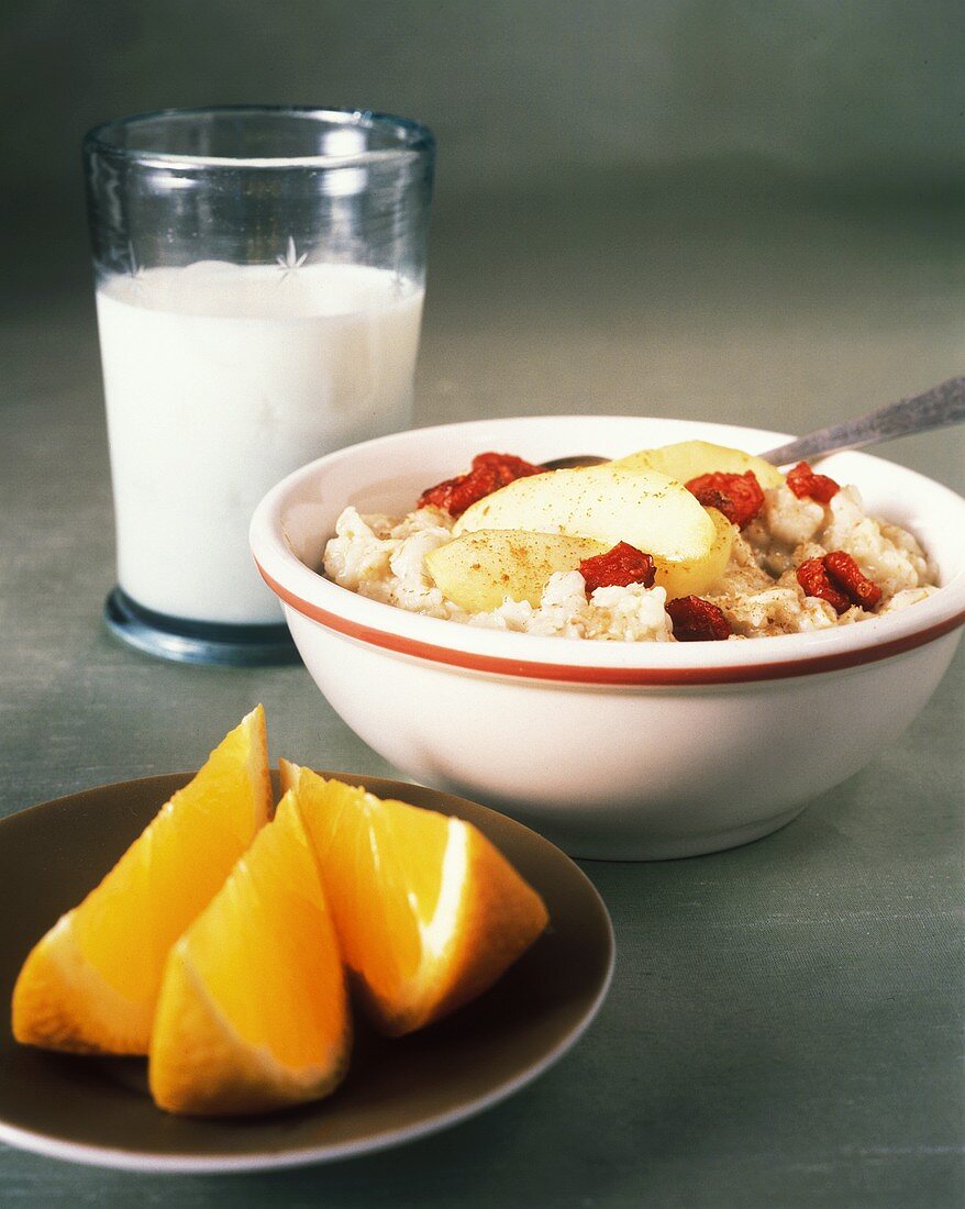 Müsli mit Obst, ein Glas Milch und Orangenschnitze