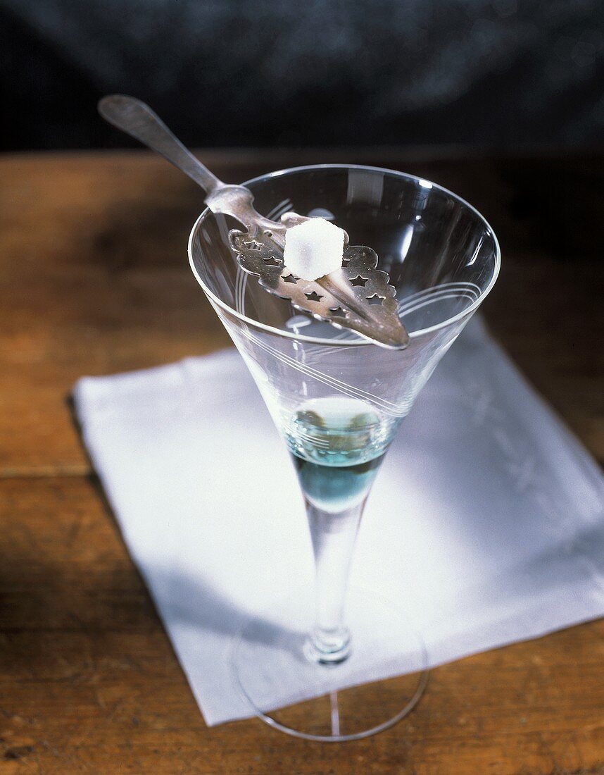 Absinth mit Zuckerwürfel auf einem Silberlöffel