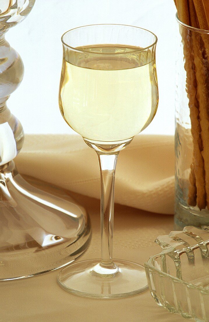 Ein Glas Weißwein, Serviette und Grissini