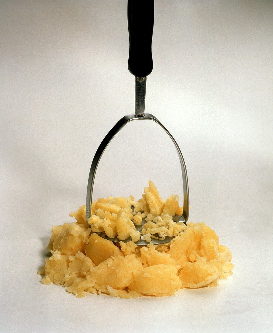 Gekochte Kartoffeln mit Kartoffelstampfer