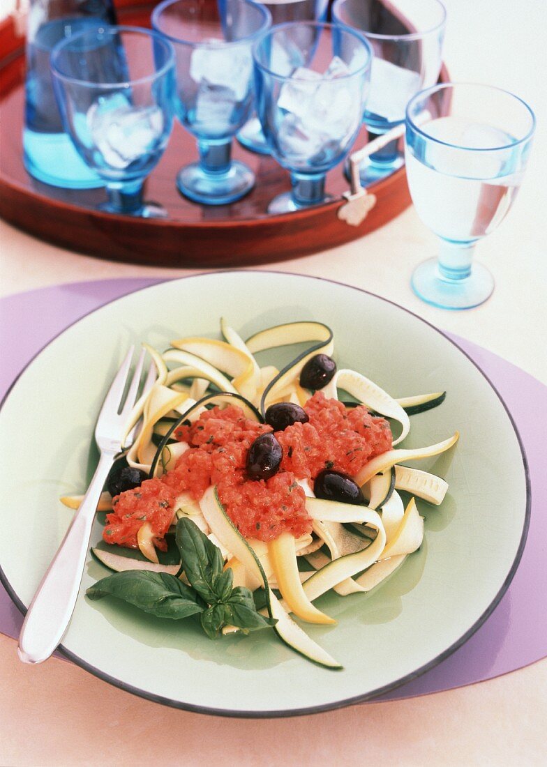 Zucchinistreifen mit Tomatensauce und schwarzen Oliven