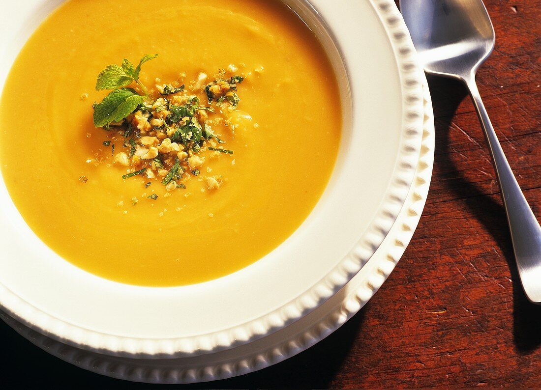 Sweet Potato Soup Topped with Crushed Peanuts and Mint