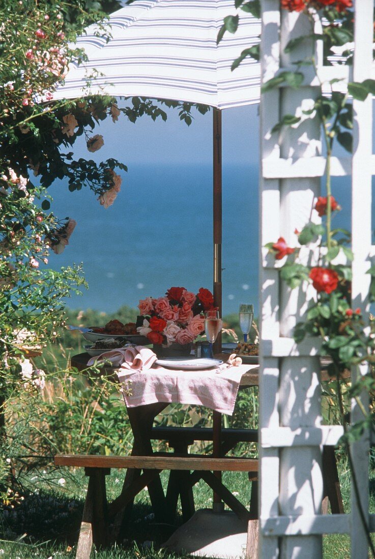Gedeckter Tisch im Garten mit Blick aufs Meer
