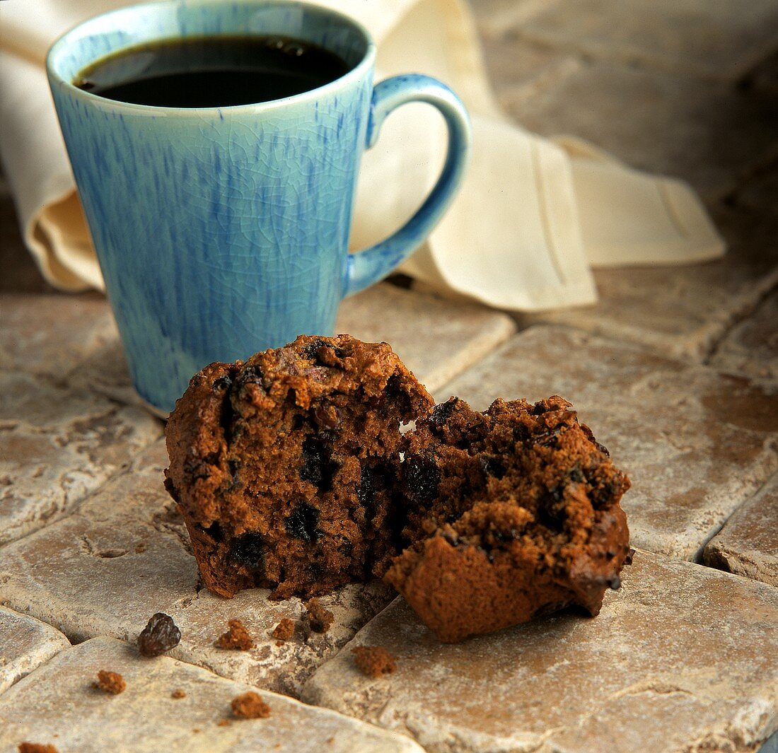 Zimt-Rosinen-Muffin vor einer Tasse Kaffee