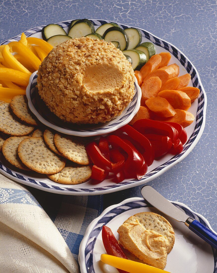 A Cheese Ball with Sliced Vegetables and Crackers