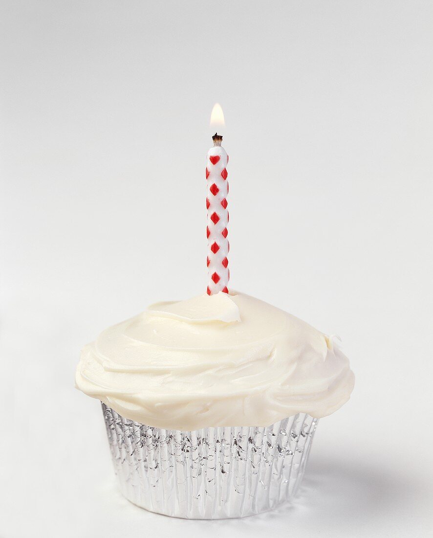 Cupcake mit Vanilleglasur und einer Kerze