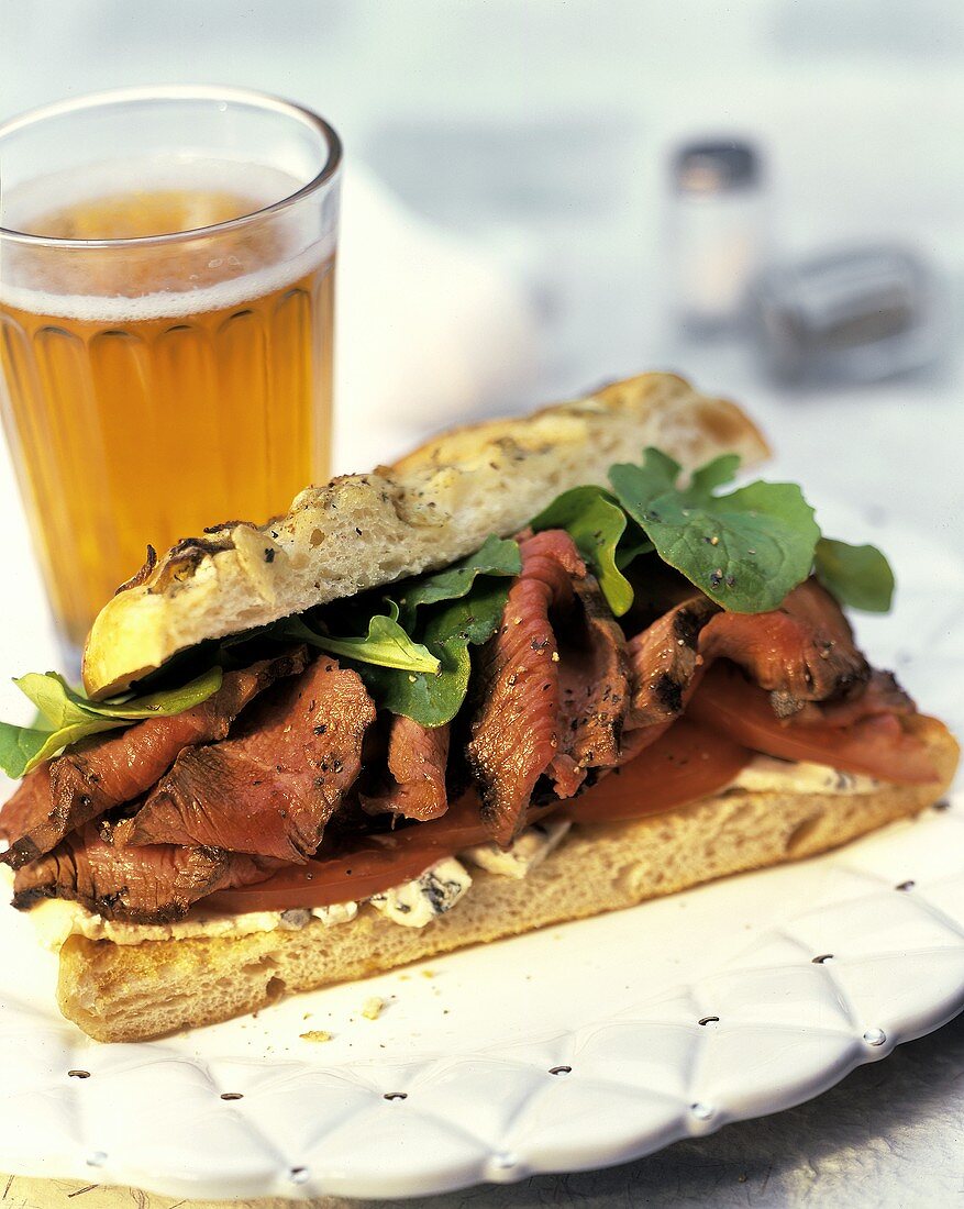 Sandwich mit Roastbeef und Tomaten; Glas Bier