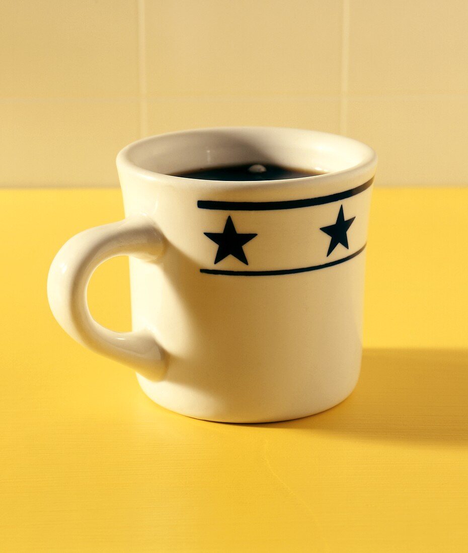 Schwarzer Kaffee in grosser Tasse mit Sternen