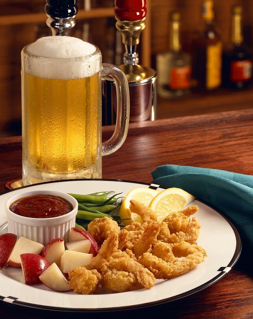 Fritierte Garnelen mit roten Kartoffeln und Dip; Bier