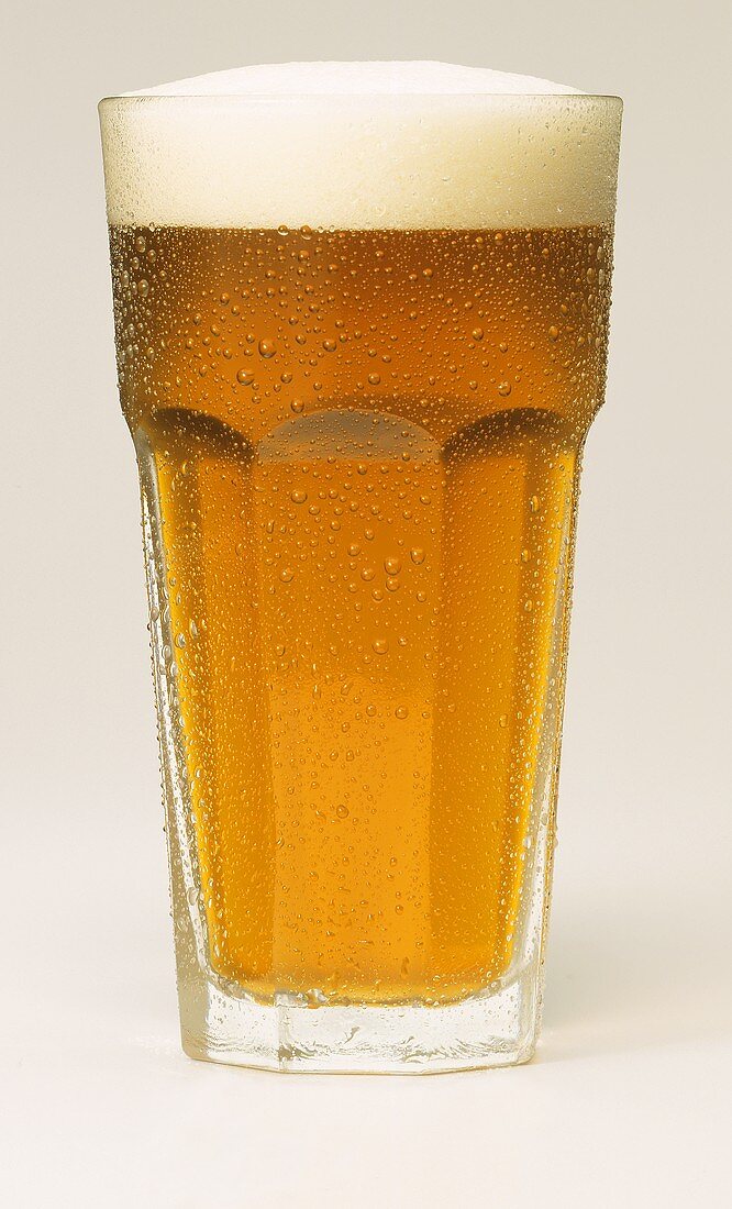 A glass of beer with a head of froth