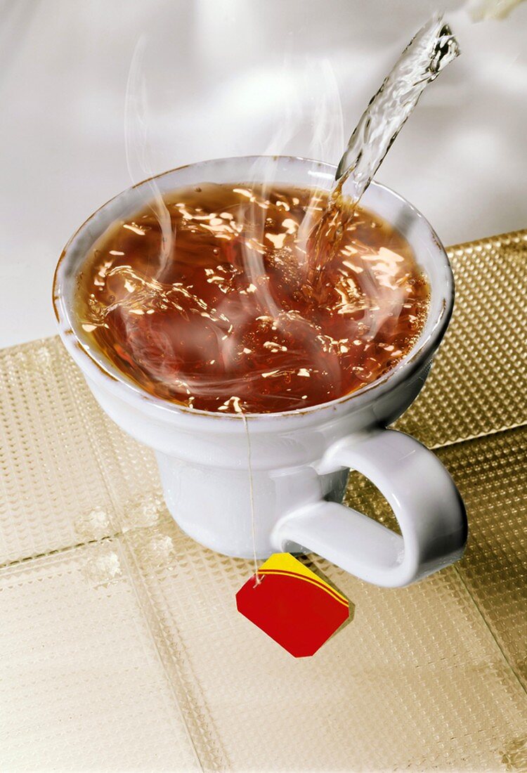 Heisses Wasser in Teetasse gießen