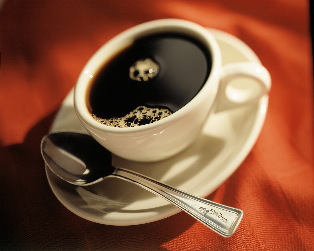 Schwarzer Kaffee in weisser Tasse mit Löffel