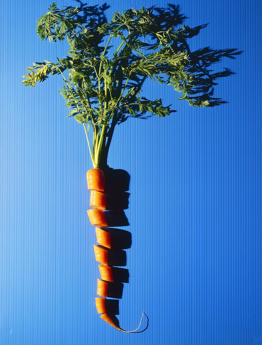 Eine Karotte mit Grün, in Scheiben geschnitten