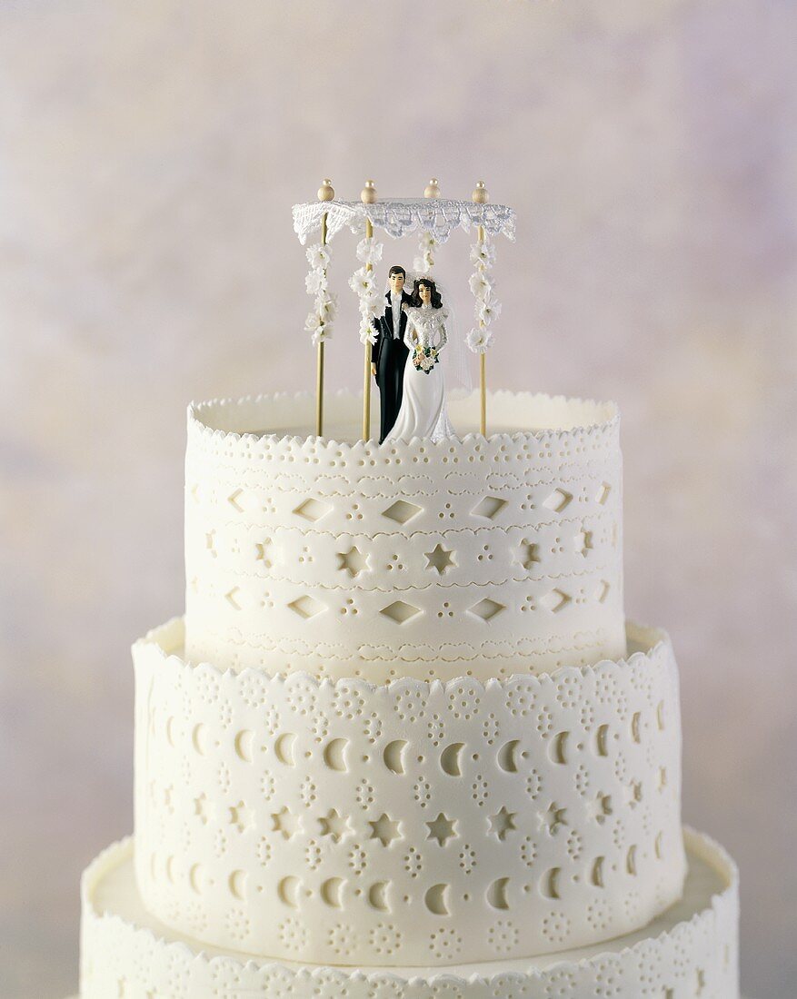 A Three Tiered Wedding Cake/ Chuppa with Bride and Groom