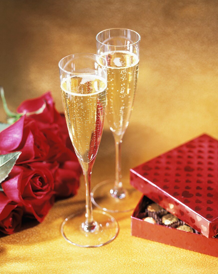 Champagnerkelche mit Rosen und Pralinenschachtel