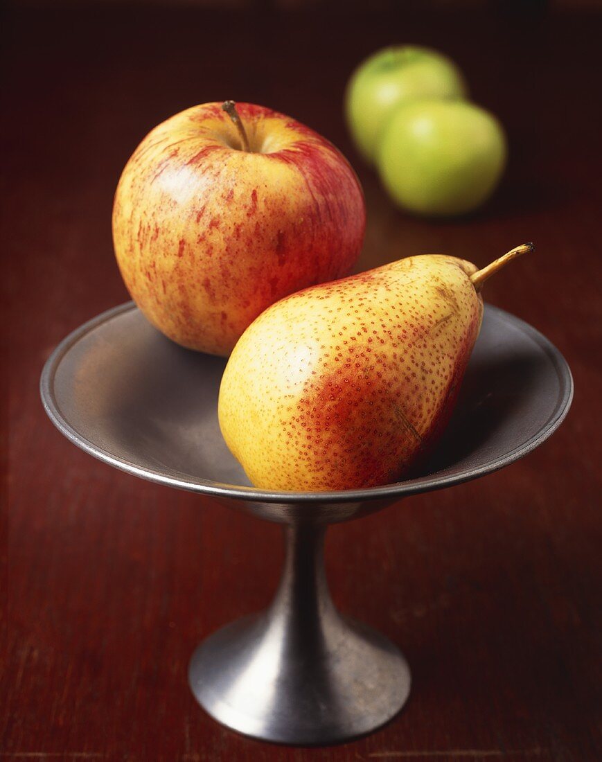 A Ripe Bartlett Pear and a Gala Apple in a Pewter Dish