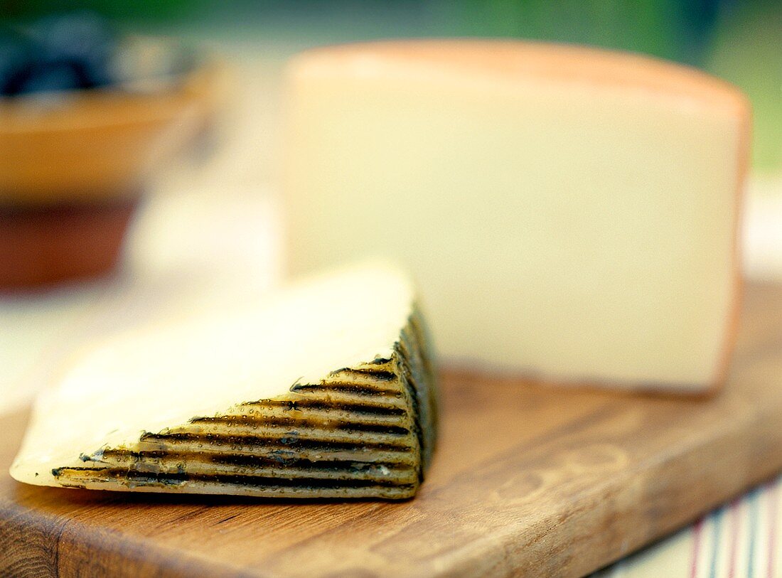 Stück Manchego-Käse auf einem Holzbrett