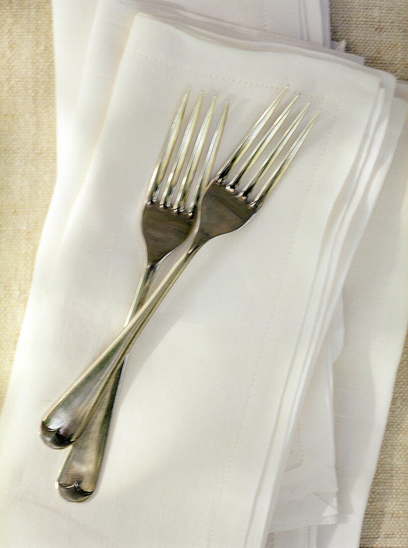 Two Forks Crossed on a Linen Napkin