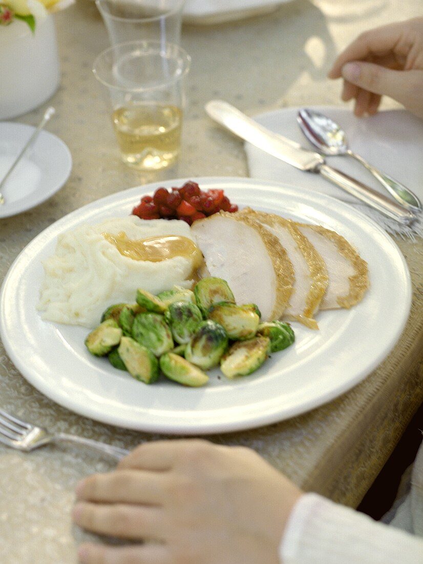 Putenbraten mit Rosenkohl und Püree auf gedecktem Tisch