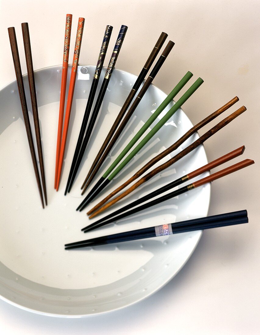 Eight pairs of chopsticks on a white plate
