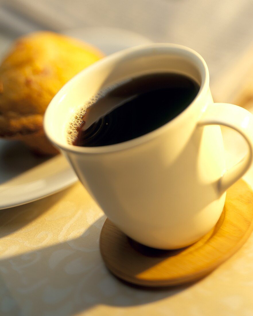 Tasse schwarzer Kaffee vor Muffin