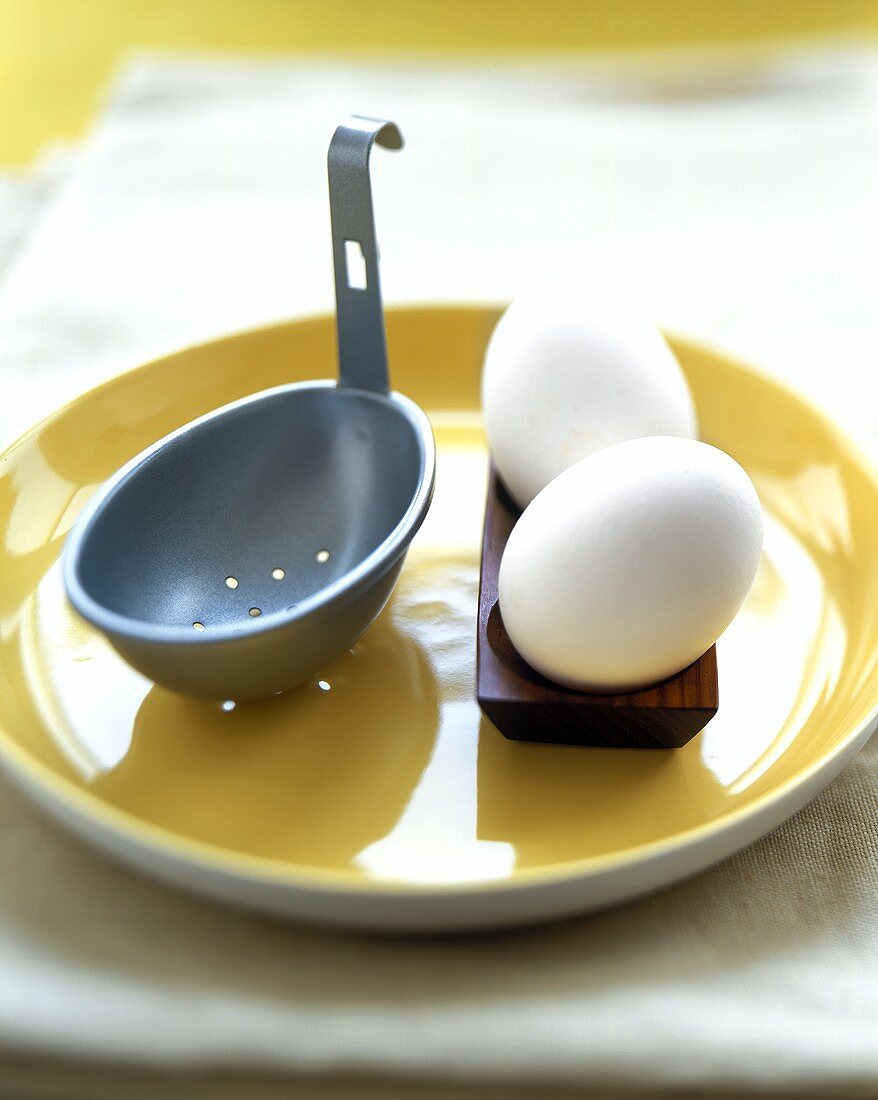 An Egg Poacher with Two White Eggs on a Yellow Plate