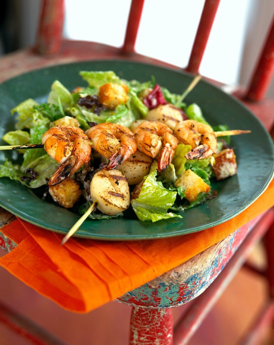 Caesar salad with grilled shrimp and scallop kebabs 