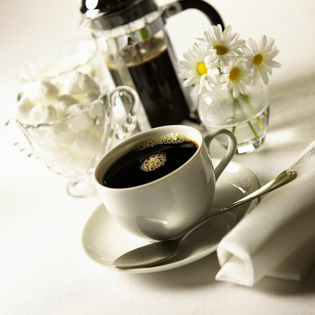 Schwarzer Kaffee in weisser Tasse; Zuckerwürfel