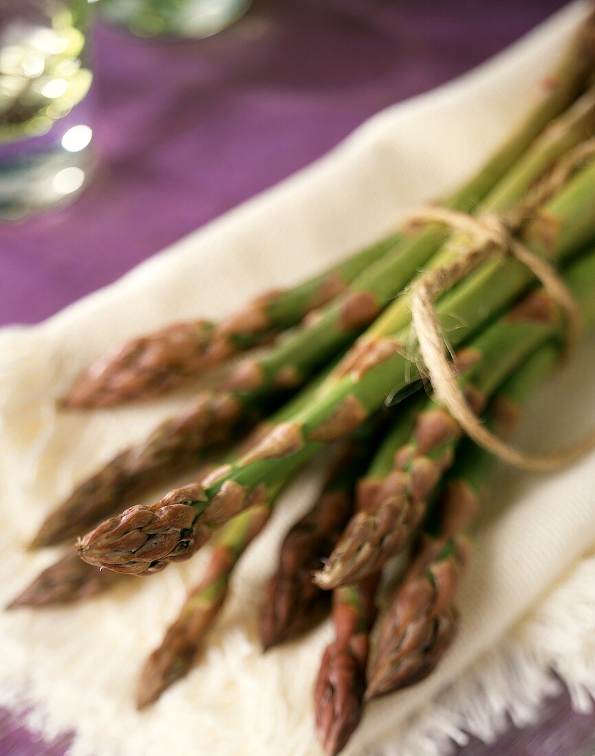 Fresh green asparagus spears on a white napkin
