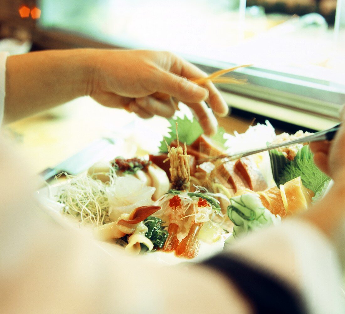 Ein Koch bereitet eine gemischte Sushi-Platte