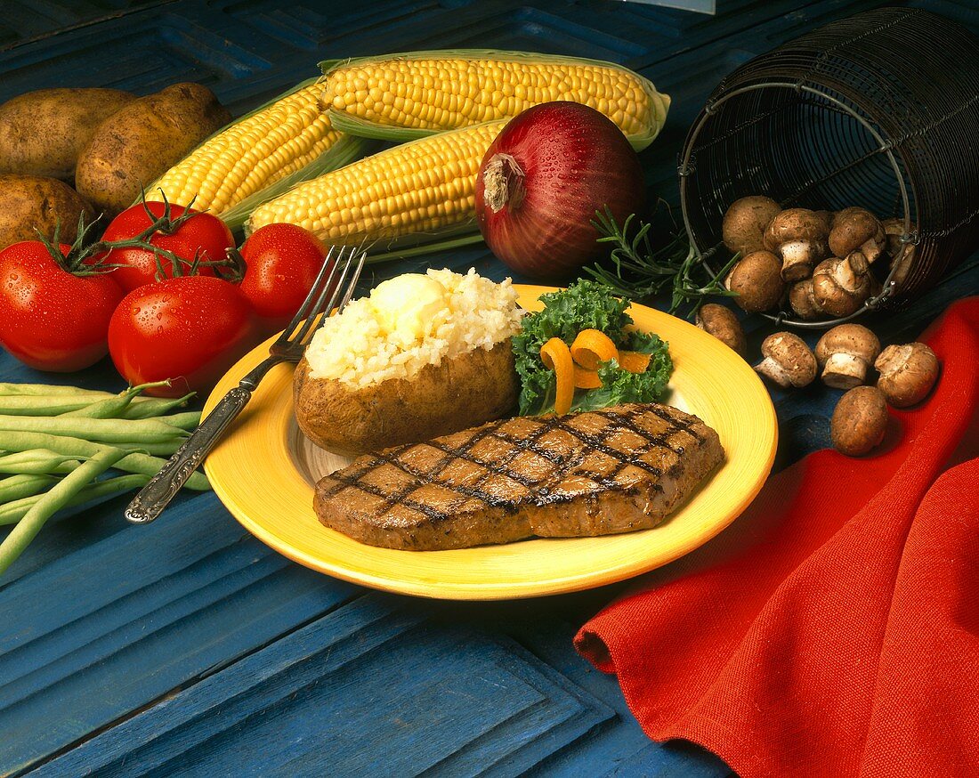 Gegrilltes Rindersteak mit Folienkartoffel, Gemüse, Mais, Pilze