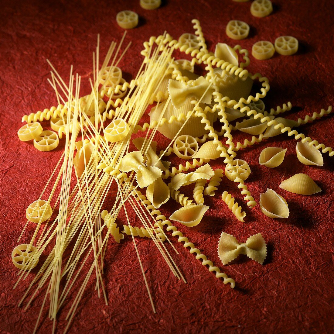 Assorted Dried Pasta on Red Background