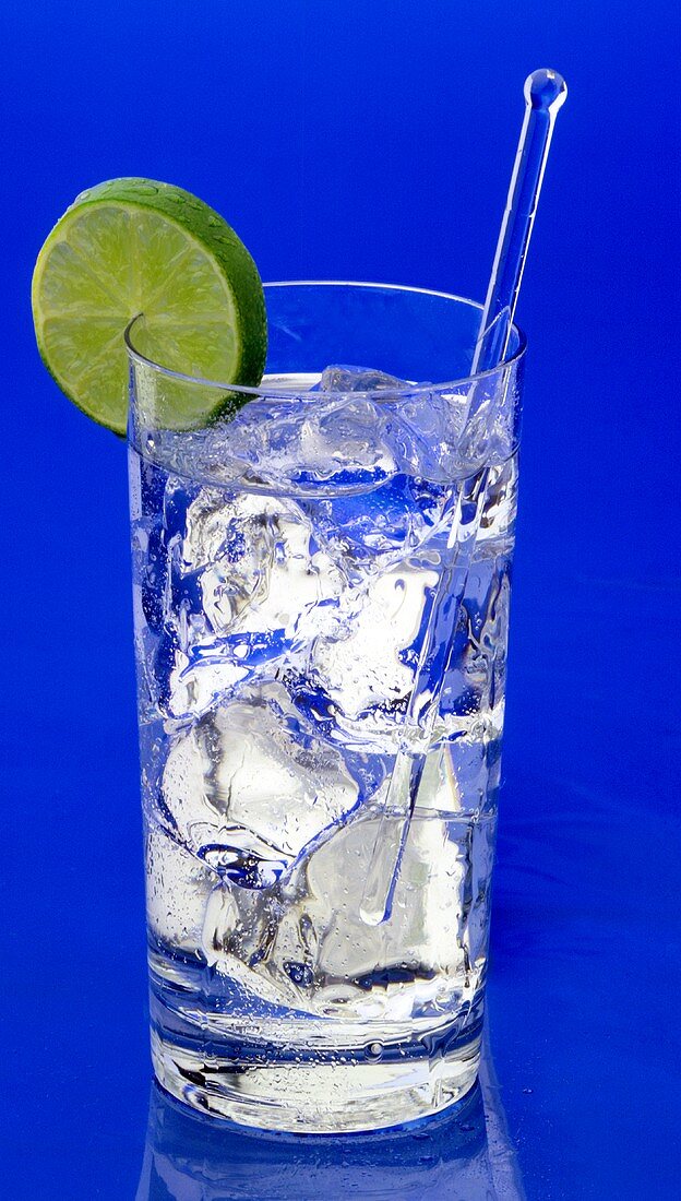 Gin and tonic in glass with ice cubes and lime