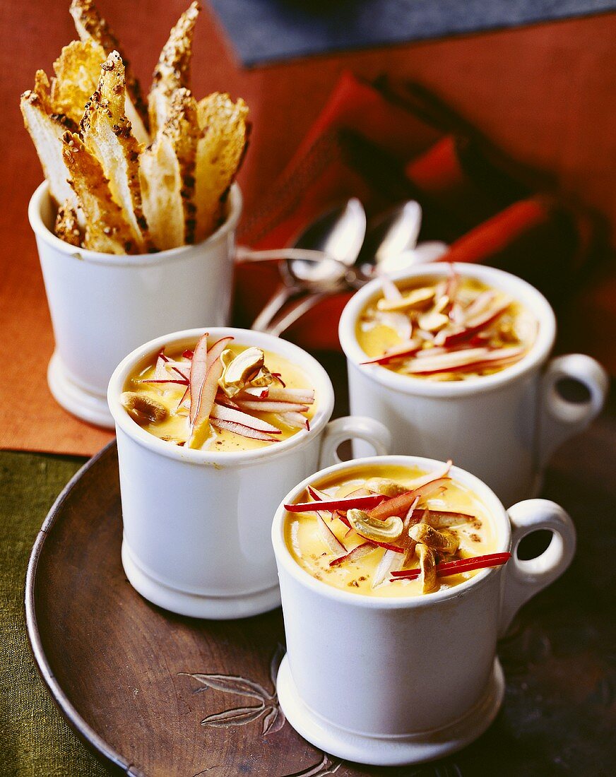 Pumpkin soup with mushrooms and strips of apple in three cups