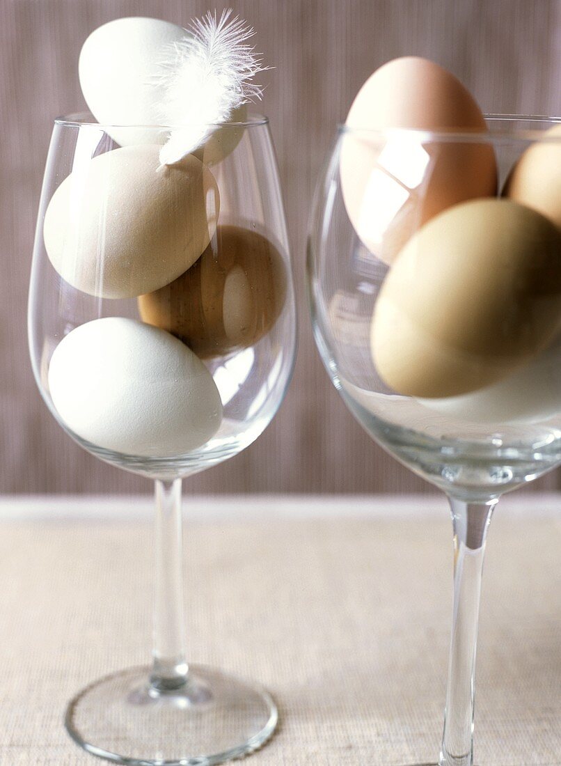 White and brown eggs in wine glasses