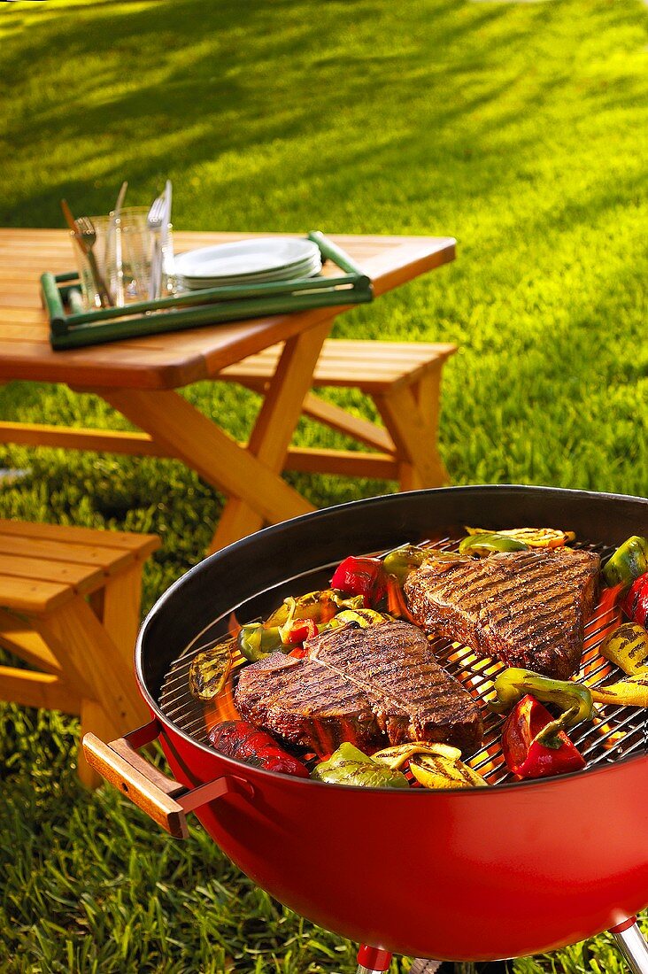 Steaks and vegetables on a barbecue in garden