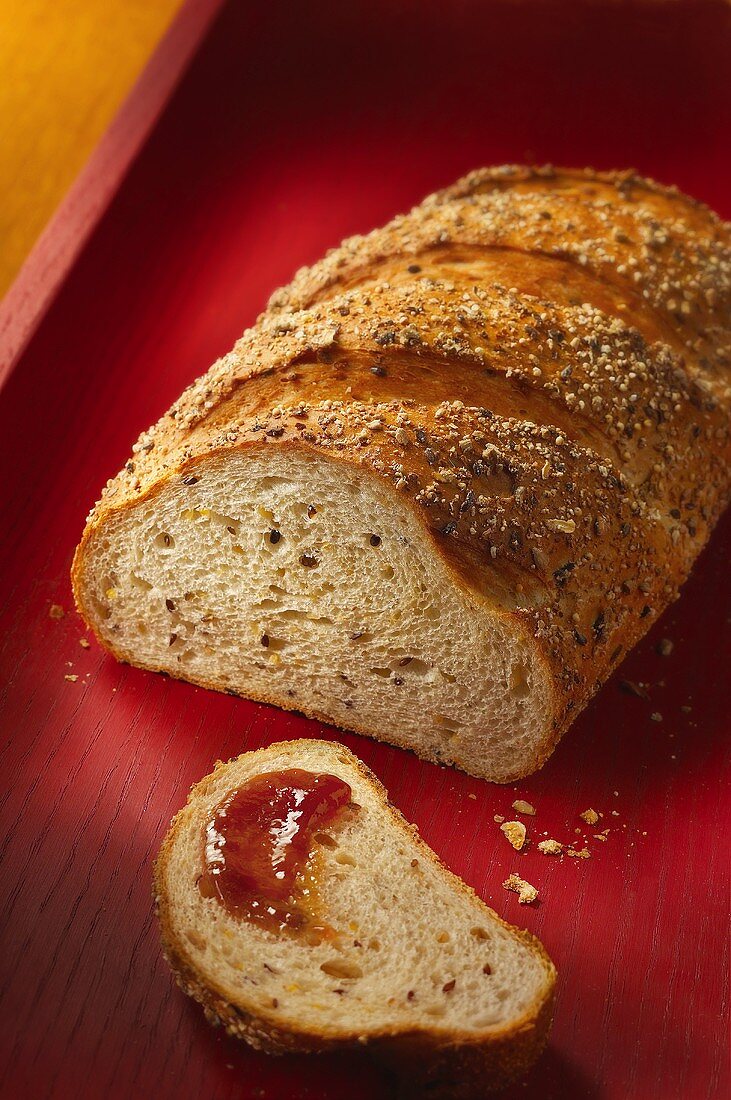 Mehrkornbrot, eine Scheibe mit Marmelade bestrichen