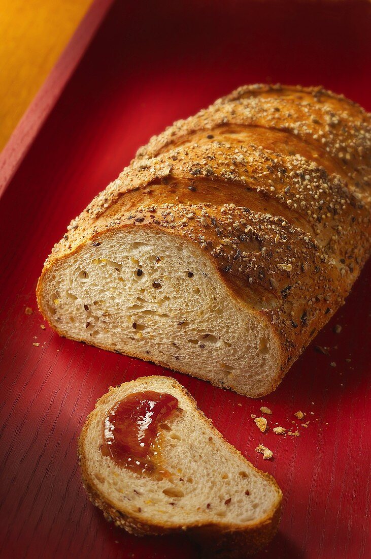 Mixed-grain bread, one slice spread with jam