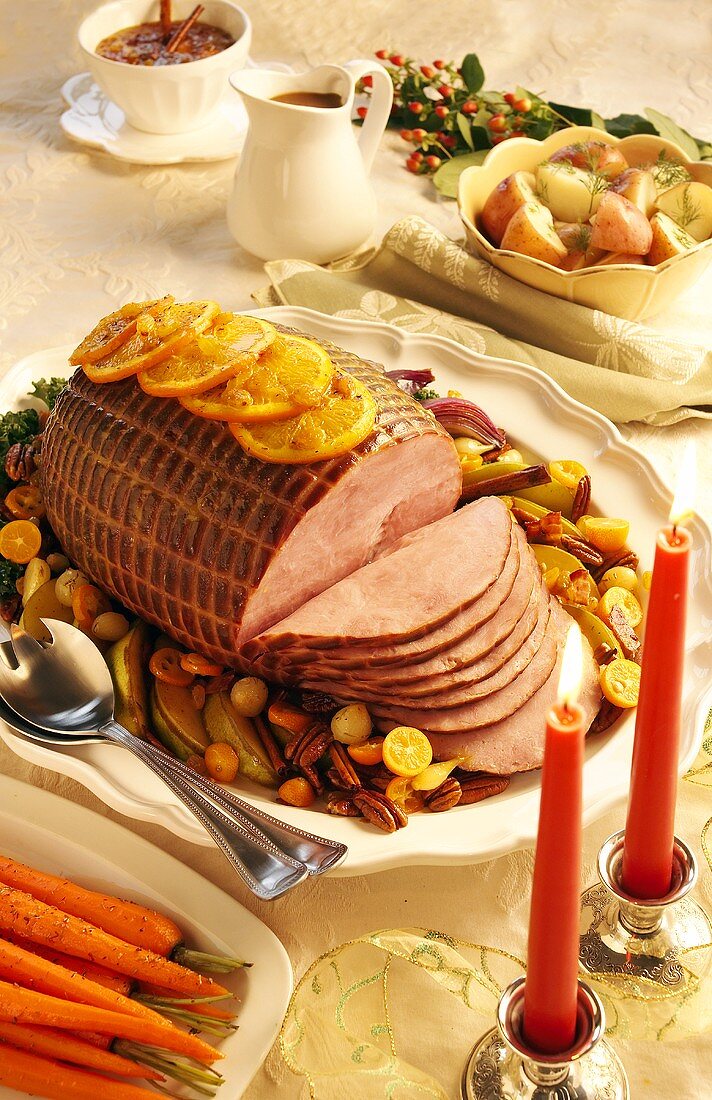 Festive roast ham, slices carved on serving plate