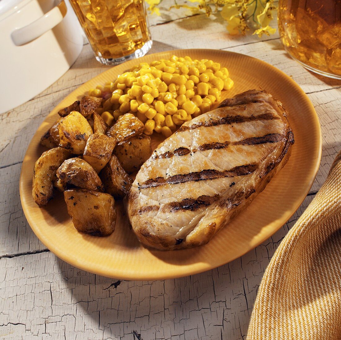 Ein gegrilltes Schweinesteak mit Kartoffeln & Mais