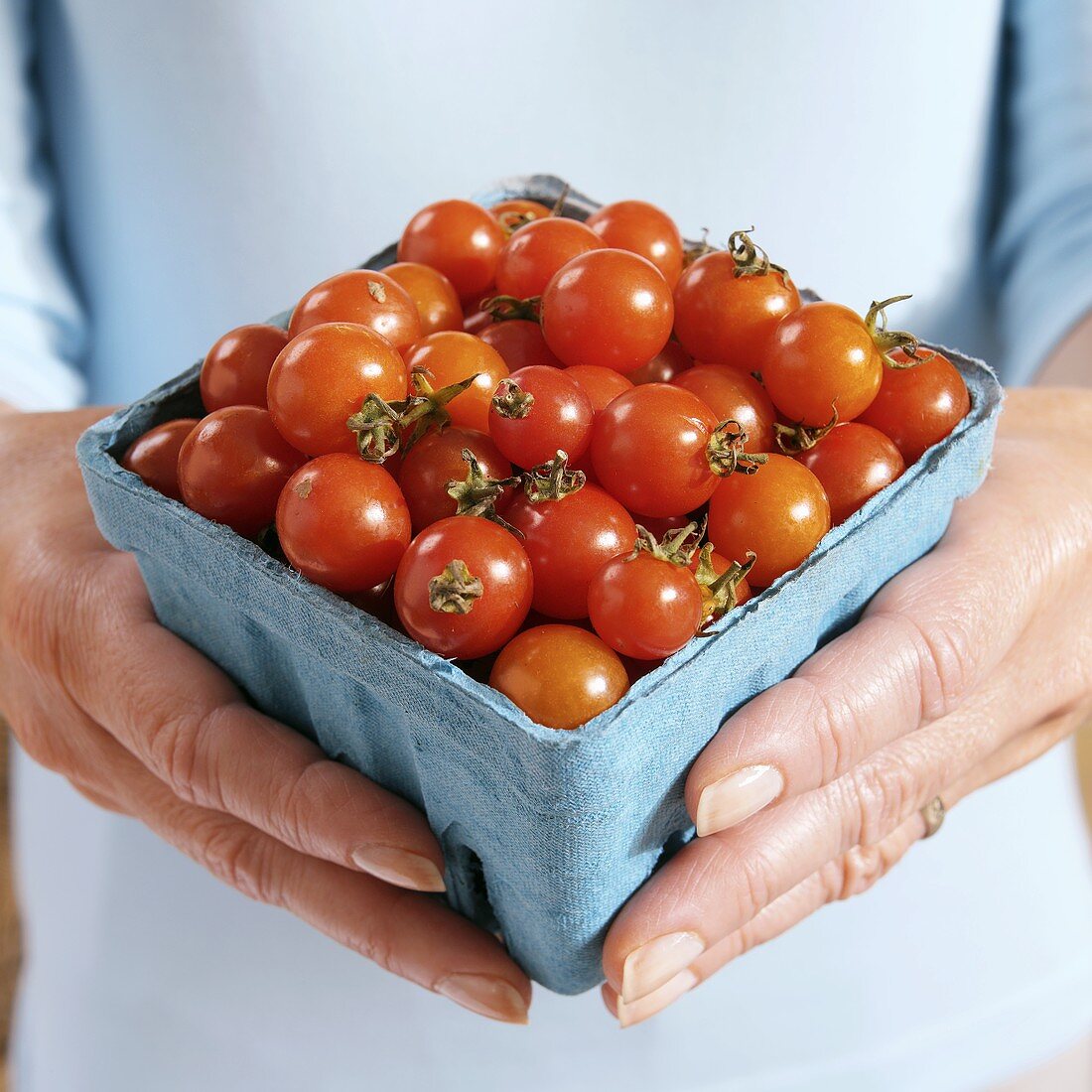 Hands Holding a Container of Grape Tomatoes