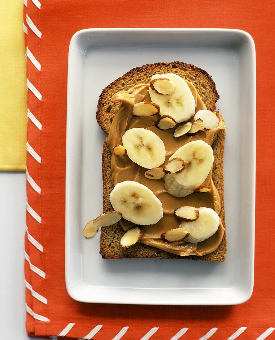 A Slice of Whole Wheat Bread with Peanut Butter, Bananas and Almonds